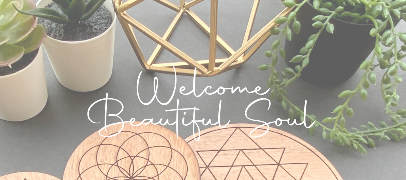 This is a soft scene with a message Welcome Beautiful Soul with succulents, gold geometry and crystal grids
